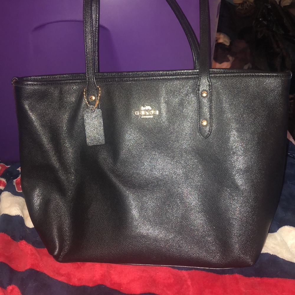 Black Coach Tote with zipper closure, 3 pockets inside. Measures 10” x 16”
